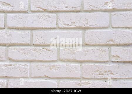 Weiße frisch lackierte Oberfläche der Ziegelfassade des alten renovierten Gebäudes. Weiße Backsteinwand Hintergrund. Stockfoto