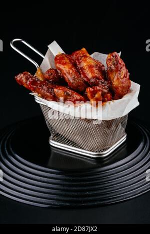 BBQ Hähnchenflügel auf schwarzem Hintergrund Stockfoto
