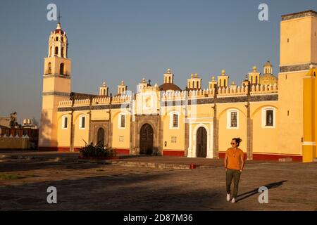 Junger Mexikaner, der vor der gelben Kirche in Cholula, Puebla, läuft Stockfoto