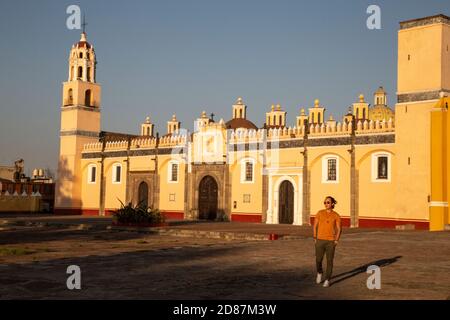 Junger Mexikaner, der vor der gelben Kirche in Cholula, Puebla, läuft Stockfoto