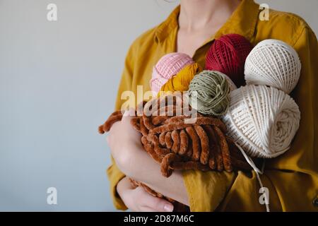 Rollen von Baumwollseilen in Frauenhand. Stricken, Häkeln, handgemachtes Hobby-Konzept Stockfoto