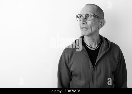 Studio shot der kahlen älterer Mann denken beim Tragen von Brillen vor weißem Hintergrund Stockfoto
