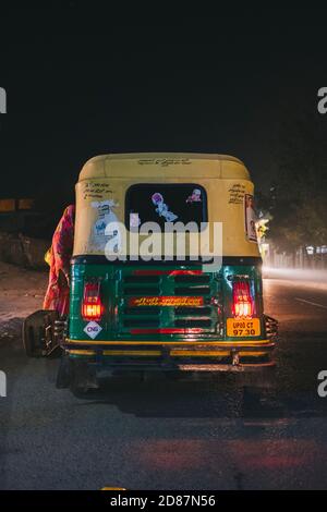 Tuk Tuk, auch bekannt als Auto, pflücken indische Frau in roten Sari während der Nacht in Agra gekleidet. Stockfoto