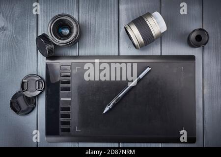 Grundlegende Werkzeuge eines Fotografen oder Grafikdesigners. Fotoobjektive und Grafik Tablet Bearbeitung Stockfoto