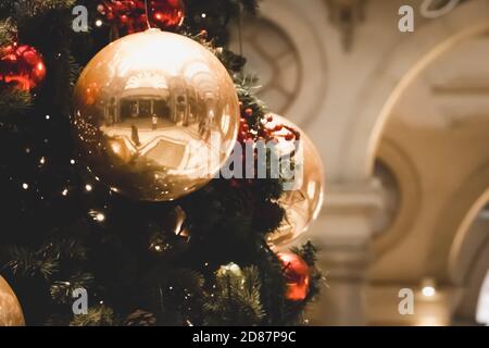 Festliche Outdoor dekorative weihnachtsbeleuchtung Hintergrund. Weihnachtsbaum Zweig mit Kugeln geschmückt, Kugeln auf architektonischen Wahrzeichen Hintergrund Stockfoto