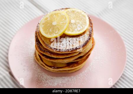 Hausgemachte Zitronen Ricotta Pfannkuchen auf einem rosa Teller, Seitenansicht. Nahaufnahme. Stockfoto