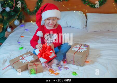 Happy Little blonde Mädchen Eröffnung Weihnachtsgeschenke Stockfoto