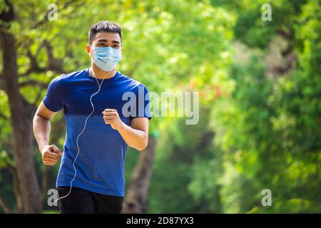 Mann in Gesichtsmaske und läuft im Park Stockfoto