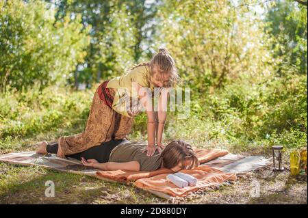 Massage Mädchen gibt ihrem Kunden eine erfrischende Massage draußen. Stockfoto