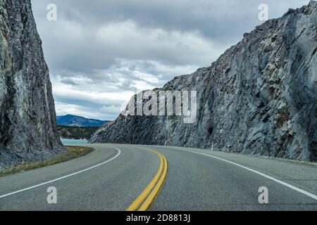 Autobahnstraße im Wald, Felsen auf beiden Seiten mit Bergen im Hintergrund. Windy Point. Alberta Highway 11 (David Thompson Highway) Stockfoto