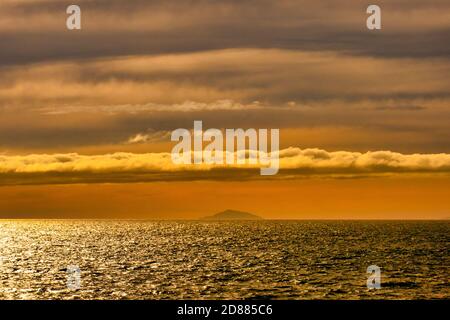 Segeln Sie bei Sonnenuntergang über die Cook Strait mit einem dramatischen Orange Himmel auf der Inter Islander Fähre Stockfoto