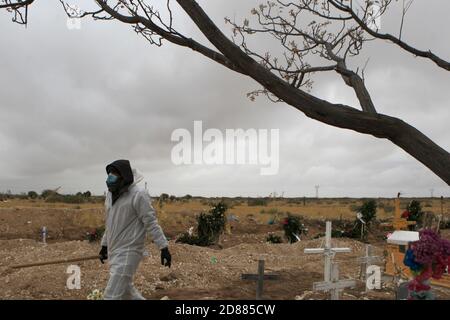 Ciudad Juarez, MEXIKO. Oktober 2020. Friedhofsarbeiter begraben die Leichen von Menschen, die mit COVID-19 infiziert wurden, in Ciudad Juarez, als eine Rauchsäule aus dem Krematorium des städtischen Friedhofs San Rafael aufsteigt. COVID-19 Opfer werden in einem separaten Teil des Friedhofs begraben. Heute erreichte Mexiko insgesamt 900,000 Fälle und fast 90,000 Todesfälle durch COVID-19. Quelle: Corrie Boudreaux/Alamy Live News Stockfoto