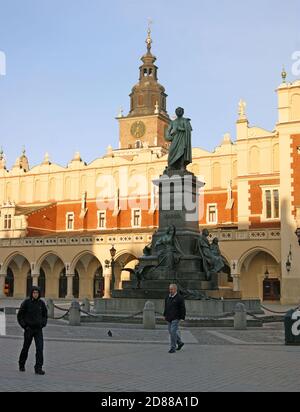 Das Adam Mickiewics Monument aus dem Jahr 1898 steht vor der Tuchhalle im Renaissance-Stil, während die Menschen 2010 auf dem Altstädter Hauptplatz in Krakau, Polen, spazieren gehen. Stockfoto