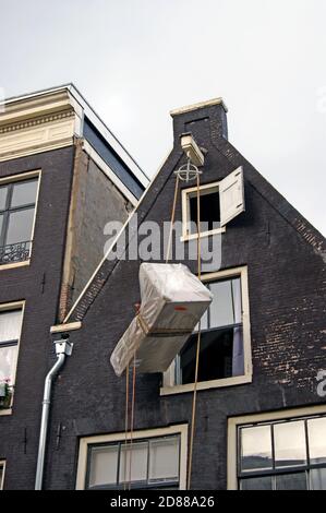 Eine Serie von Fotos zeigt das Heben von Möbeln in die obere Etage eines Kanalhauses in Amsterdam, Holland, wo Outdoor-Riemenscheibenlift-System verwendet wird. Stockfoto