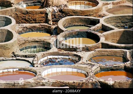 Historische runde Steinbottiche gefüllt mit natürlichen Farbstoffen in der größten und ältesten Gerberei in Fez, Medina, in der handgefertigte Lederherstellung stattfindet. Stockfoto