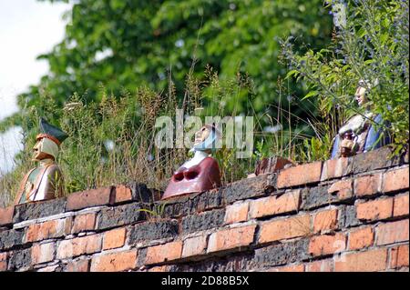 Die von Dariusz Przewiezlikowski geschaffene Büste der mittelalterlichen Burgher aus dem 15. Jahrhundert säumen eine Backsteinmauer in der Altstadt von Torun, Polen. Stockfoto