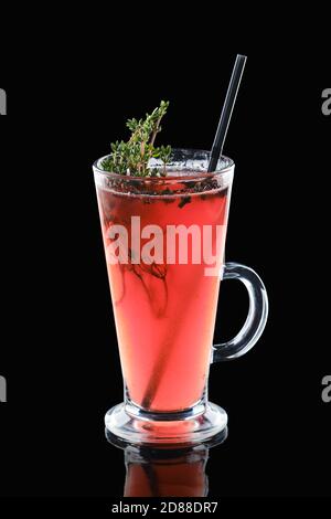 Ein Glas Cranberry und Thymian heißen Getränk isoliert auf schwarz Hintergrund Stockfoto