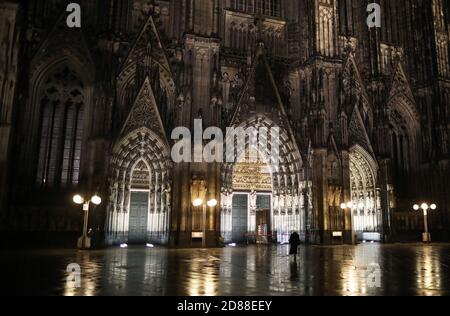 Köln, Deutschland. Oktober 2020. Eine Frau steht morgens vor der Kathedrale. Die Föderation will die Corona-Infektionszahlen mit drastischen Kontaktbeschränkungen in den Griff bekommen. Nach einem Beschlussentwurf für die Konferenz der Bundes- und Landesregierungen sollen die Maßnahmen ab dem 4. November deutschlandweit in Kraft treten und bis Ende des Monats in Kraft bleiben. Quelle: Oliver Berg/dpa/Alamy Live News Stockfoto