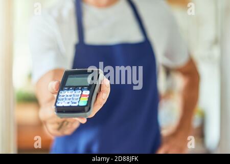 Zahlungsterminal in der Hand des Geschäftsmannes Stockfoto
