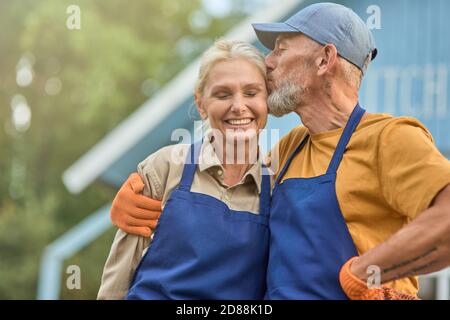 Liebende mittleren Alters kaukasischen Paar küssen und lächeln Stockfoto
