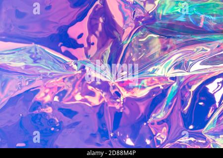 Lila weicher Fokus holografische Tapete. Zerknittert Folie Textur mit Reflexionen. Unscharfer Regenbogenhintergrund. Stockfoto