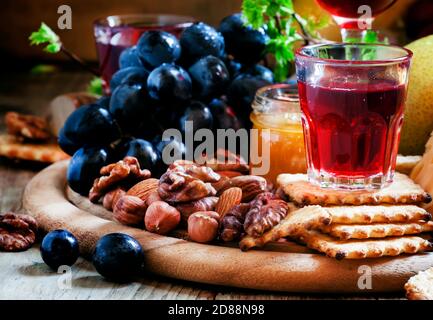 Rosenwein und Holzgericht mit verschiedenen Snacks, Vintage-Hintergrund, selektiver Fokus Stockfoto