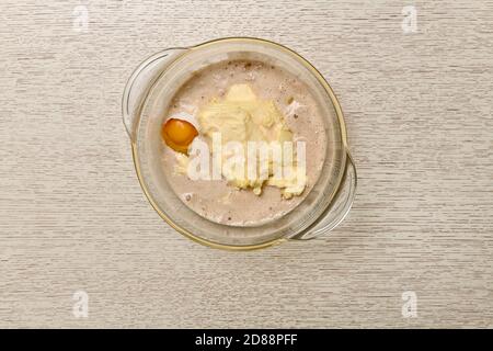 Schüssel mit verdünnter Hefe, Butter und Ei. Stockfoto
