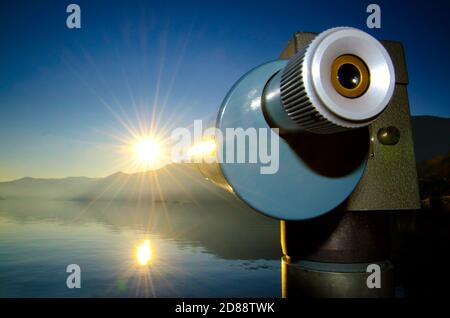 Teleskop mit Sunbeam über den Lago Maggiore mit Berg in Ascona, Tessin in der Schweiz. Stockfoto