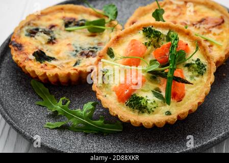 Tartlets mit Pilzen, Lachs und Huhn auf Holzgrund. Stockfoto