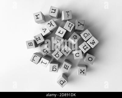 Sortiment von Kleinbuchstaben auf Würfeln in schwarz fotografiert Und weiß auf weißem Hintergrund Stockfoto