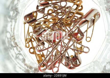 Eine direkt über Schuss eines Stapels von Metall-Sicherheitsnadeln in einem Glas. Stockfoto