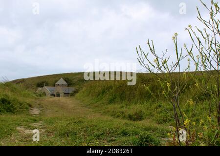 Die Kirche St. Winwaloe oder Kirche der Stürme ist die denkmalgeschützte Pfarrkirche von Gunwalloe in Cornwall, England. Inhalt Stockfoto