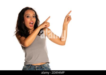 Glückliche dunkelhäutige Frau zeigt auf weißem Hintergrund Stockfoto