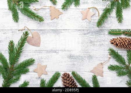 Weihnachtshintergrund mit Tannenzweig und Holzdeko auf Holztisch. Umweltfreundlicher, natürlicher Rahmen. Draufsicht. Kopierbereich - Bild Stockfoto