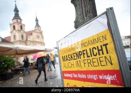 28. Oktober 2020, Baden-Württemberg, Ludwigsburg: "Enthält das Coronanvirus. Masken müssen auch im Freien getragen werden. Achtung! Das Risiko steigt wieder!" Steht auf einem Schild in der Innenstadt. Aufgrund der zunehmenden Zahl neuer Infektionen mit dem Coronavirus diskutieren Bund und Länder über eine erneute Verschärfung der Maßnahmen zur Eindämmung der Pandemie. Foto: Sebastian Gollnow/dpa Stockfoto