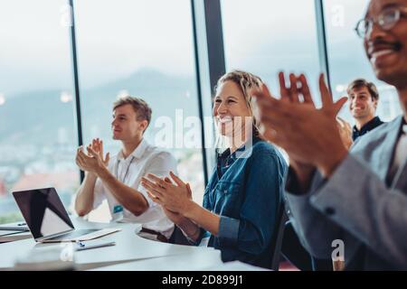 Gruppe von männlichen und weiblichen Business-Profis klatschen Hände in Konferenz. Publikum applaudiert nach erfolgreichem Seminar. Stockfoto