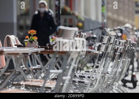 Köln, Deutschland. Oktober 2020. Eine Blume steht auf einem Tisch vor einem Restaurant. Die Bundesregierung will die Corona-Infektionszahlen mit drastischen Kontaktbeschränkungen in den Griff bekommen. Nach einem Beschlussentwurf für die Konferenz der Bundes- und Landesregierungen sollen die Maßnahmen ab dem 4. November deutschlandweit in Kraft treten und bis Ende des Monats in Kraft bleiben. Quelle: Rolf Vennenbernd/dpa/Alamy Live News Stockfoto