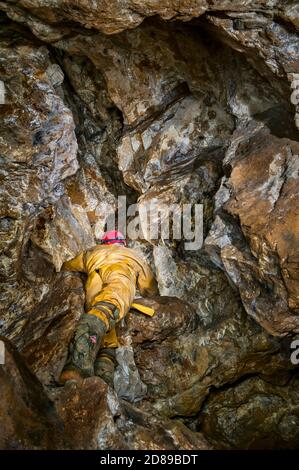 Klettern in das Dach eines ausgearbeiteten Rohrvenen in einer alten Bleimine in Derbyshire, mit Bergarbeiter-Pickwork auf jeder Oberfläche. Stockfoto