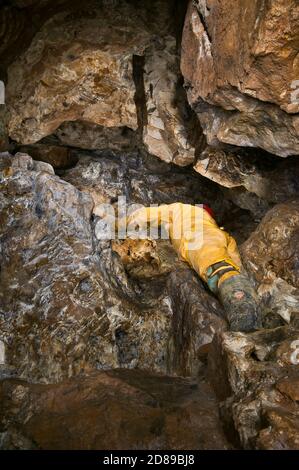 Klettern in das Dach eines ausgearbeiteten Rohrvenen in einer alten Bleimine in Derbyshire, mit Bergarbeiter-Pickwork auf jeder Oberfläche. Stockfoto