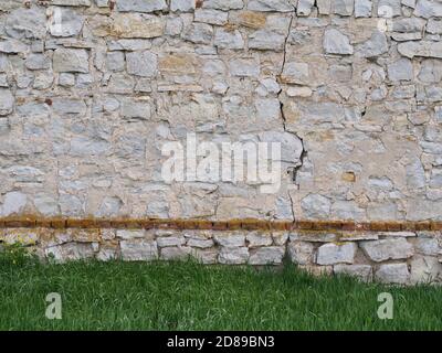 Steinmauer auf dem Rasen Wiese Hintergrund Stockfoto