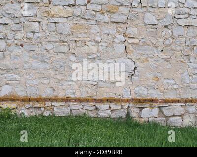 Steinmauer auf dem Rasen Wiese Hintergrund Stockfoto