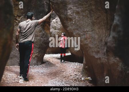 Höhlenforschung, Erkundung einer Höhle. Junge Entdecker wandern durch einen schmalen Pfad in Höhlen und Höhlen in Estrecho de la Arboleja oder Agualeja in Stockfoto