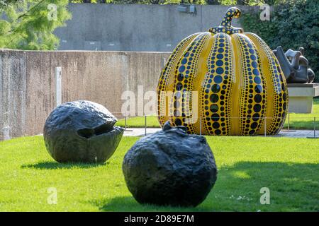 Yayoi Kasumas Kunstwerk 'Pumpkin' befindet sich hinter Lucia Fontanas Bronzeskulptur 'Spacial Concept: Nature' im Skulpturengarten des Hirshhorn Museums. Stockfoto