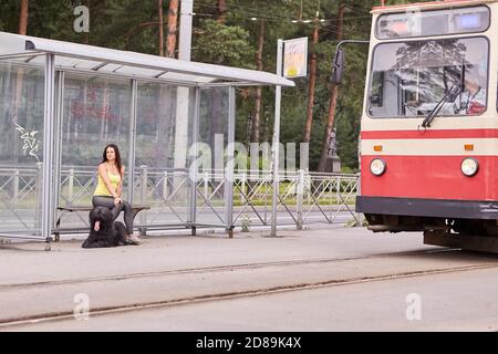 Straßenbahn fährt nach Woman und briard an der Haltestelle der öffentlichen Verkehrsmittel. Stockfoto
