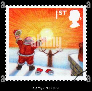 GROSSBRITANNIEN - UM 2004: Eine in Großbritannien gedruckte Briefmarke zeigt den Weihnachtsmann, der die aufgehende Sonne anschaut, um 2004 Stockfoto