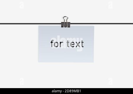Ein kleines Stück Papier mit Aufschrift für Text, geklemmt durch Binder Clip an einen Draht und hängen daran. Isoliert auf Weiß. Nahaufnahme, Kopierbereich Stockfoto