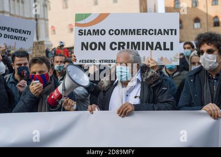 Bologna, 28/10/2020. Manifest dei commercianti e dei lavoratori del commercio contro le chiusure imposte dal nuovo decreto del Governo per arginare l'aumento dei contagi da Covid-19. Presenti le maggiori associazioni come conferesercenti e confcommercio, molti Slogan contro il Governo e il Presidente Giuseppe Conte, alcuni esponenti dell'estrema destra in piazza. Presidio in piazza Maggiore e piccolo corteo in Centro guidato dallo striscione „TU CI chiudi, tu CI paghi“. (MICHELE LAPINI/Fotograf, Bologna - 2020-10-28) p.s. la foto e' utilizzabile nel rispetto del contesto in cui e' stat Stockfoto