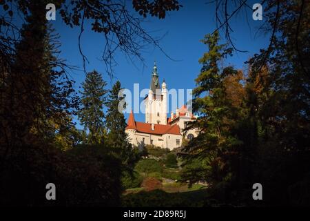 Pruhonice, Tschechische Republik - Oktober 25 2020: Blick auf die berühmte romantische Burg auf einem Hügel in einem Park mit grünen Bäumen umgeben. Sonnig. Stockfoto