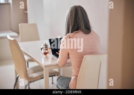 Freiberufliche Mitarbeiterin, die zu Hause am Notebook arbeitet Stockfoto