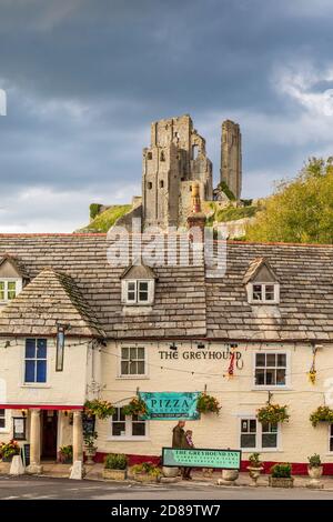 The Greyhound Inn in 'The Square' at Corfe mit Corfe Castle im Hintergrund, Dorset, England Stockfoto